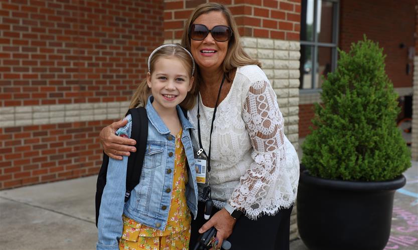 A principal smiles with a student